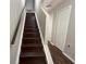 Dark wood staircase with white risers and white trim contrasted by dark wood-look flooring at 2320 Whispering Trails Pl, Winter Haven, FL 33884