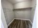 A walk-in closet features wire shelving for storage and wood look tile flooring at 2320 Whispering Trails Pl, Winter Haven, FL 33884