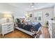 Inviting bedroom featuring queen bed, ceiling fan, wood floors, and natural light at 2444 Merida Cir, The Villages, FL 32162