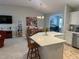 Bright dining area features tile floors, an elegant chandelier, and is adjacent to the kitchen island at 2444 Merida Cir, The Villages, FL 32162