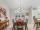 Bright dining room with elegant chandelier, views to the kitchen, and a side serving table at 2444 Merida Cir, The Villages, FL 32162