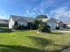 Inviting home exterior with a lush green lawn and pretty landscaping at 2444 Merida Cir, The Villages, FL 32162