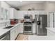 Modern kitchen with stainless steel appliances, white cabinets, and ample counter space at 2444 Merida Cir, The Villages, FL 32162