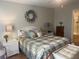 Comfortable main bedroom featuring a queen bed with decorative pillows and a stylish wreath on the wall at 2444 Merida Cir, The Villages, FL 32162