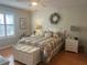 Cozy main bedroom with a decorative wreath above a comfortable queen bed and a sunny window at 2444 Merida Cir, The Villages, FL 32162