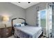 Bedroom featuring neutral tones, with a luxury vinyl plank flooring, a window for natural light and soft blue bedding at 245 Citrus Pointe Dr, Haines City, FL 33844