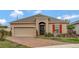 Charming single-story home featuring a paver driveway, two-car garage, and landscaped front yard at 245 Citrus Pointe Dr, Haines City, FL 33844