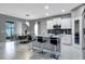 Modern kitchen featuring white cabinets, stainless steel appliances, an island with bar seating, and an adjacent dining area at 245 Citrus Pointe Dr, Haines City, FL 33844