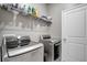 A modern laundry room featuring a new silver washer and dryer and a wire shelf for storage at 245 Citrus Pointe Dr, Haines City, FL 33844