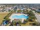 Aerial view of a community pool surrounded by palm trees, lounge chairs and neighborhood homes at 245 Citrus Pointe Dr, Haines City, FL 33844