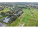 Overhead view of the neighborhood, featuring mature trees, golf course and beautiful landscaping at 24548 Calusa Blvd, Eustis, FL 32736