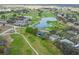 Community aerial view showcases a golf course, pond, clubhouse, and many beautiful residential homes at 24548 Calusa Blvd, Eustis, FL 32736