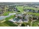 Aerial view of the community highlighting lush greenery, a lake, golf course and residential homes at 24548 Calusa Blvd, Eustis, FL 32736