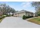 View of the side of the home showing a long driveway to the garage at 24548 Calusa Blvd, Eustis, FL 32736