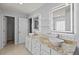 Bathroom featuring dual sinks, granite countertops, white cabinets, and decorative mirrors at 24548 Calusa Blvd, Eustis, FL 32736