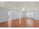 Spacious main bedroom featuring a tray ceiling, fan, and beautiful wood floors at 24548 Calusa Blvd, Eustis, FL 32736