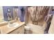 Bathroom featuring a shower-tub combination with neutral-colored tiles and a decorative shower curtain at 255 Matisse Ave, The Villages, FL 32162