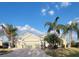 Attractive single-story home with palm trees, an American flag, and a large driveway at 255 Matisse Ave, The Villages, FL 32162