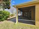 View of the covered, screened-in patio from the backyard of the property at 2668 Alandari Ln, The Villages, FL 32162