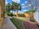 The backyard is landscaped with grass, trees, bushes, and red mulch near the property's fence at 2668 Alandari Ln, The Villages, FL 32162