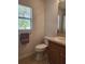 Bathroom featuring a toilet and a single sink vanity near a window at 2668 Alandari Ln, The Villages, FL 32162