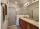 Bathroom with double vanity sinks and glass-door shower at 2668 Alandari Ln, The Villages, FL 32162