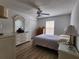 Bedroom with hardwood floors, ceiling fan, and white furniture at 2668 Alandari Ln, The Villages, FL 32162