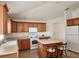 Bright kitchen with an island, white appliances, wooden cabinetry, and lots of natural light at 2668 Alandari Ln, The Villages, FL 32162