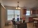 Cozy eat-in kitchen features a glass-topped table, oak cabinetry, and natural light from the large window at 2668 Alandari Ln, The Villages, FL 32162