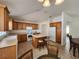 Bright kitchen featuring an island with stools, wooden cabinetry, and white appliances at 2668 Alandari Ln, The Villages, FL 32162