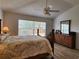 Well-lit bedroom with a woven headboard bed, side tables with lamps, and a bright window at 2668 Alandari Ln, The Villages, FL 32162