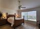 Well-lit bedroom with a woven headboard bed, side tables with lamps, and a large window at 2668 Alandari Ln, The Villages, FL 32162