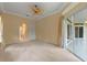 Bedroom featuring carpet, fan, recessed lights, doors, and view to the sunroom at 27710 Snow Orchid Ct, Leesburg, FL 34748