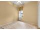 This bedroom features neutral carpet, paint, a ceiling fan and has a window overlooking the exterior at 27710 Snow Orchid Ct, Leesburg, FL 34748