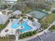 Aerial shot showcasing a community pool, tennis courts, lush landscaping, and clubhouse at 27710 Snow Orchid Ct, Leesburg, FL 34748