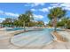 Zero entry community pool surrounded by lounge chairs, umbrellas, lush palm trees and comfortable seating at 27710 Snow Orchid Ct, Leesburg, FL 34748