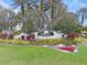 Beautifully landscaped community entrance sign, 'Legacy of Leesburg' surrounded by manicured lawn and colorful plants at 27710 Snow Orchid Ct, Leesburg, FL 34748