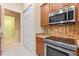 Kitchen featuring granite counters and stainless steel appliances, providing a modern and functional cooking area at 27710 Snow Orchid Ct, Leesburg, FL 34748