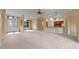 Spacious living room with carpet flooring and an open layout to the kitchen at 27710 Snow Orchid Ct, Leesburg, FL 34748