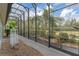 View of the pool enclosure from outside, featuring a view of trees and nature at 27710 Snow Orchid Ct, Leesburg, FL 34748