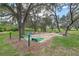 Outdoor shuffleboard court with mature trees and manicured landscaping at 27710 Snow Orchid Ct, Leesburg, FL 34748