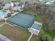 Aerial view of well-maintained tennis courts and bocce ball, surrounded by mature trees at 27710 Snow Orchid Ct, Leesburg, FL 34748