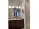 Bathroom featuring a double vanity with granite countertops, modern lighting, and warm cabinets at 294 Captiva Dr, Davenport, FL 33896