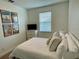 Comfortable bedroom featuring travel-themed wall decor, a cozy bed, and natural light at 294 Captiva Dr, Davenport, FL 33896