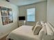 Cozy bedroom with a full sized bed, modern decor, and ample natural light from the window at 294 Captiva Dr, Davenport, FL 33896