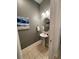 Stylish powder room featuring neutral tones, decorative art, and pedestal sink at 294 Captiva Dr, Davenport, FL 33896