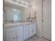 Bathroom vanity with granite countertops, white cabinets, chrome hardware and decorative mosaic backsplash at 305 Ranchwood Dr, Leesburg, FL 34748