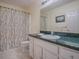 Bathroom showcasing vanity with green countertop and bamboo-themed shower curtain at 305 Ranchwood Dr, Leesburg, FL 34748