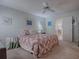 Cozy bedroom features floral bedding, carpet, and a ceiling fan at 305 Ranchwood Dr, Leesburg, FL 34748