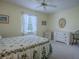 Bedroom with bright yellow walls, ceiling fan, floral accents, and white dressers at 305 Ranchwood Dr, Leesburg, FL 34748